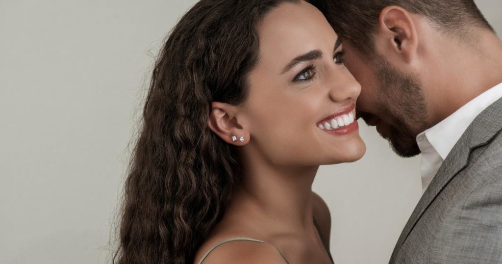 Man and woman embracing, smiling.