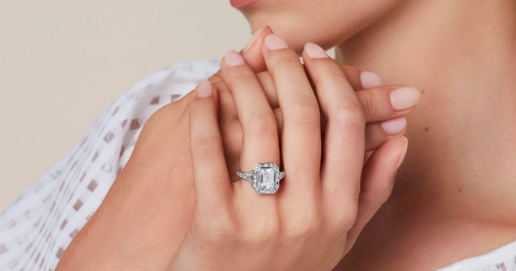 Emerald diamond ring on a model's finger